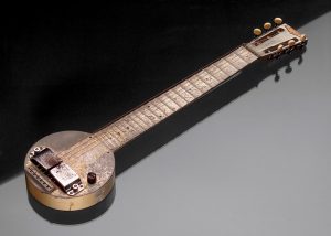 Imagem exibindo o primeiro modelo comercialmente viável de guitarra amplificada, criado por George Beauchamp e Adolph Rickenbaker, produzido em 1931.